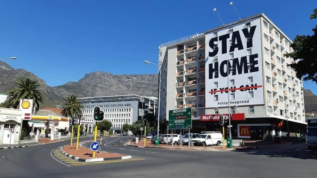 Outdoor com a mensagem "Stay at Home" no topo de um edifício na Cidade do Cabo, África do Sul, durante o confinamento da covid-19.