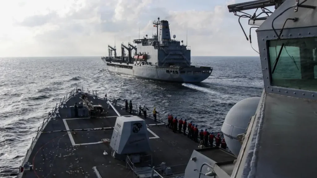 Destróier da marinha dos Estados Unidos USS Frank E. Petersen Jr. a navegar no Mar da Arábia ao lado de um navio-tanque de reabastecimento