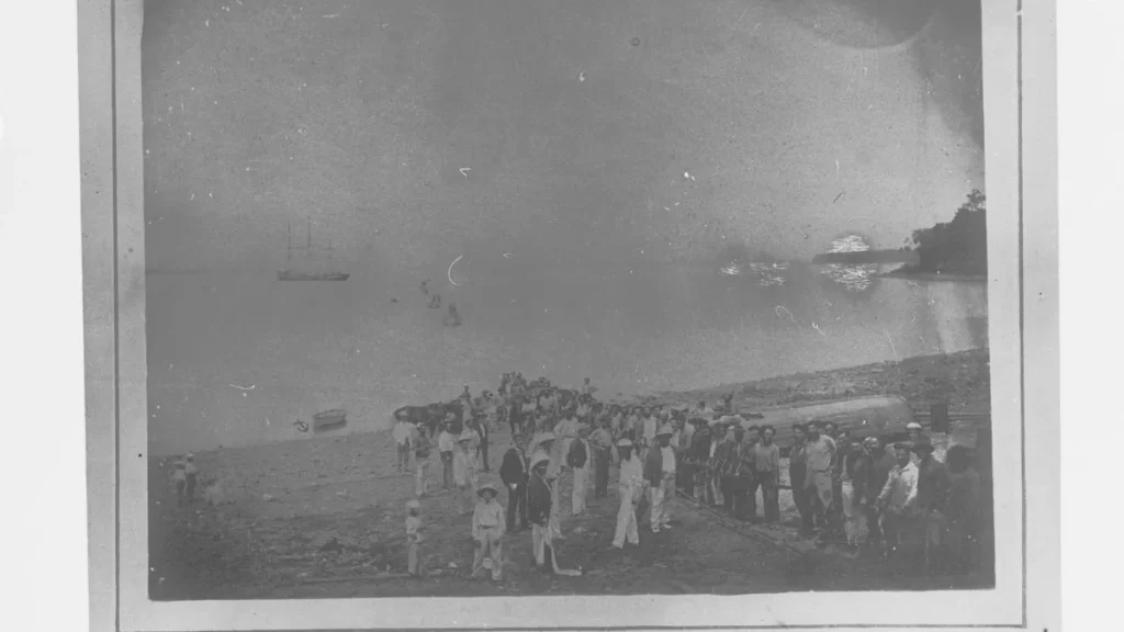 Aterragem do cabo submarino em Port Darwin, na Austrália, em 7 de novembro de 1871, com homens a puxar o cabo do mar para a praia.