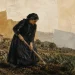 Mulher de luto a sachar uma horta numa aldeia de pedra do noroeste de Portugal