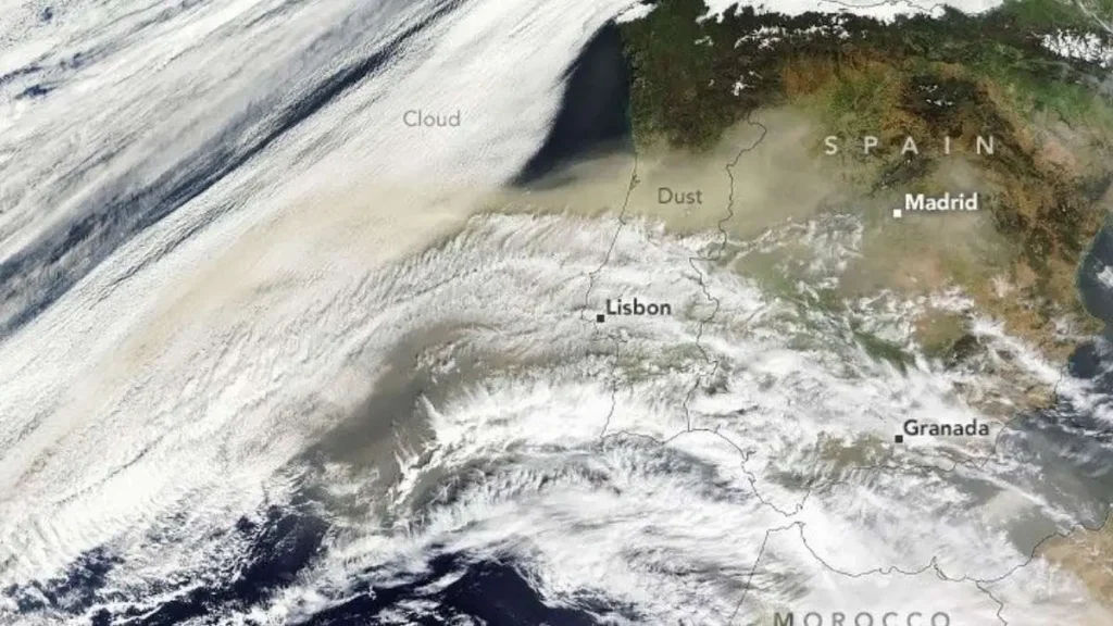 Imagem de satélite da Península Ibérica coberta por um véu castanho de poeira mineral vinda do norte de África, as chamadas poeiras do saara, com o Atlântico a oeste e o Mediterrâneo a leste